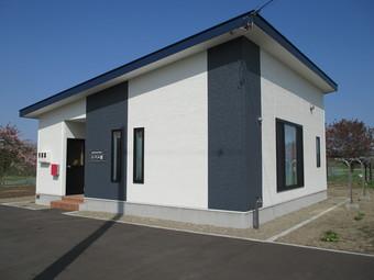 白色と黒色の外壁で陸屋根になっている移住体験住宅『のぞみ館』の写真